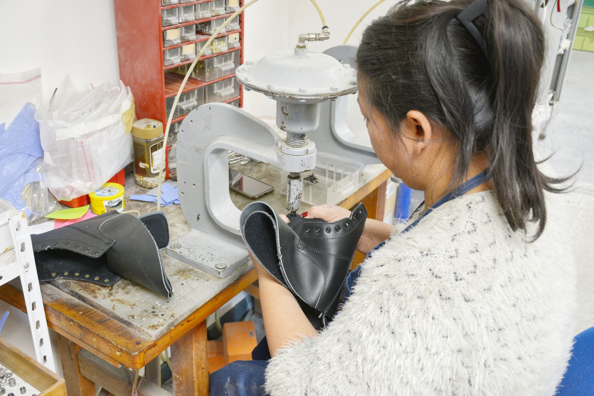 Une professionnelle de santé utilise une machine pour la fabrication de chaussures