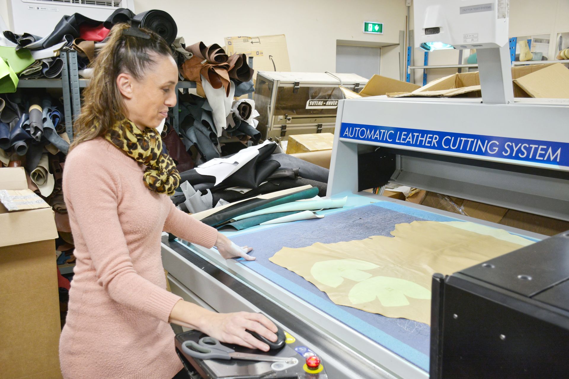 Une professionnelle utilise une machine de fabrication de chaussures