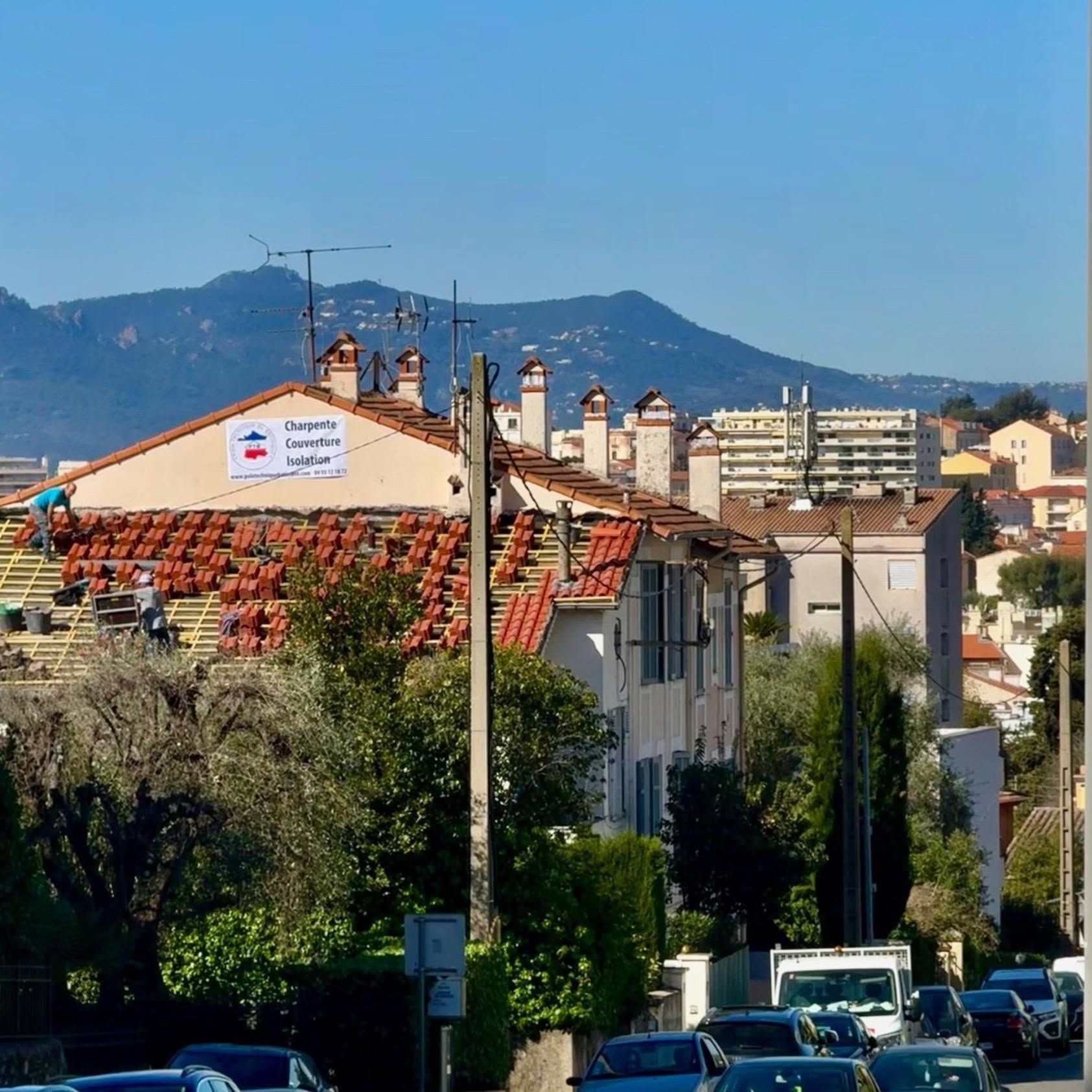 Ville ensoleillée à flanc de colline, avec ses bâtiments aux toits rouges