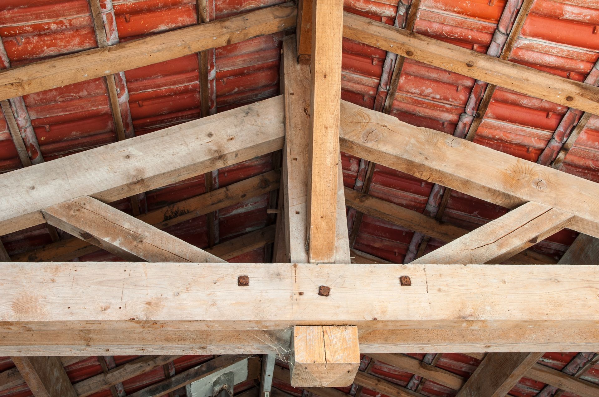 Charpente en bois et tuiles en terre cuite rouge à l'intérieur d'une structure de combles