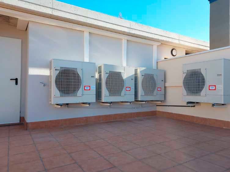 Una fila de aparatos de aire acondicionado en el costado de un edificio.