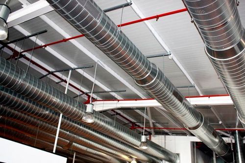 Un montón de tuberías cuelgan del techo de un edificio.