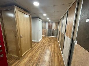 Un pasillo lleno de puertas de madera y una exposición de diferentes tipos de madera.