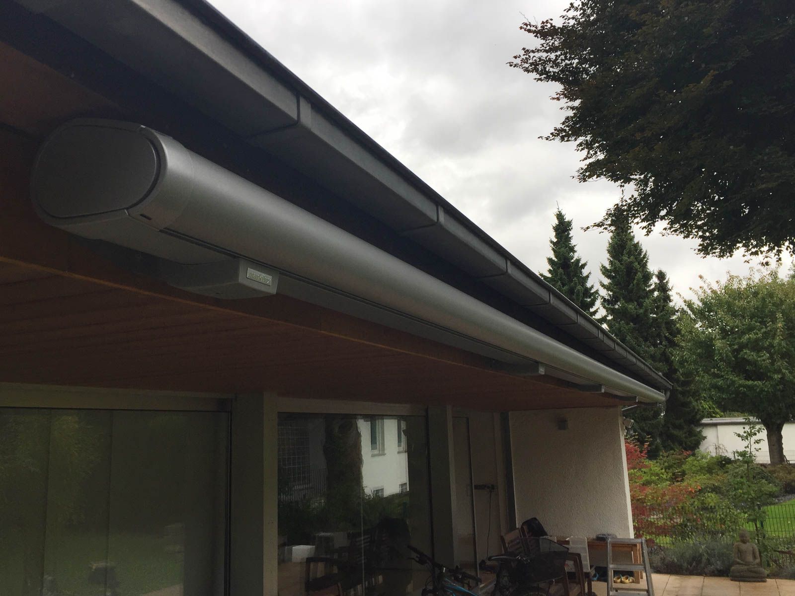 Eine weiße Markise hängt vom Dach eines Hauses