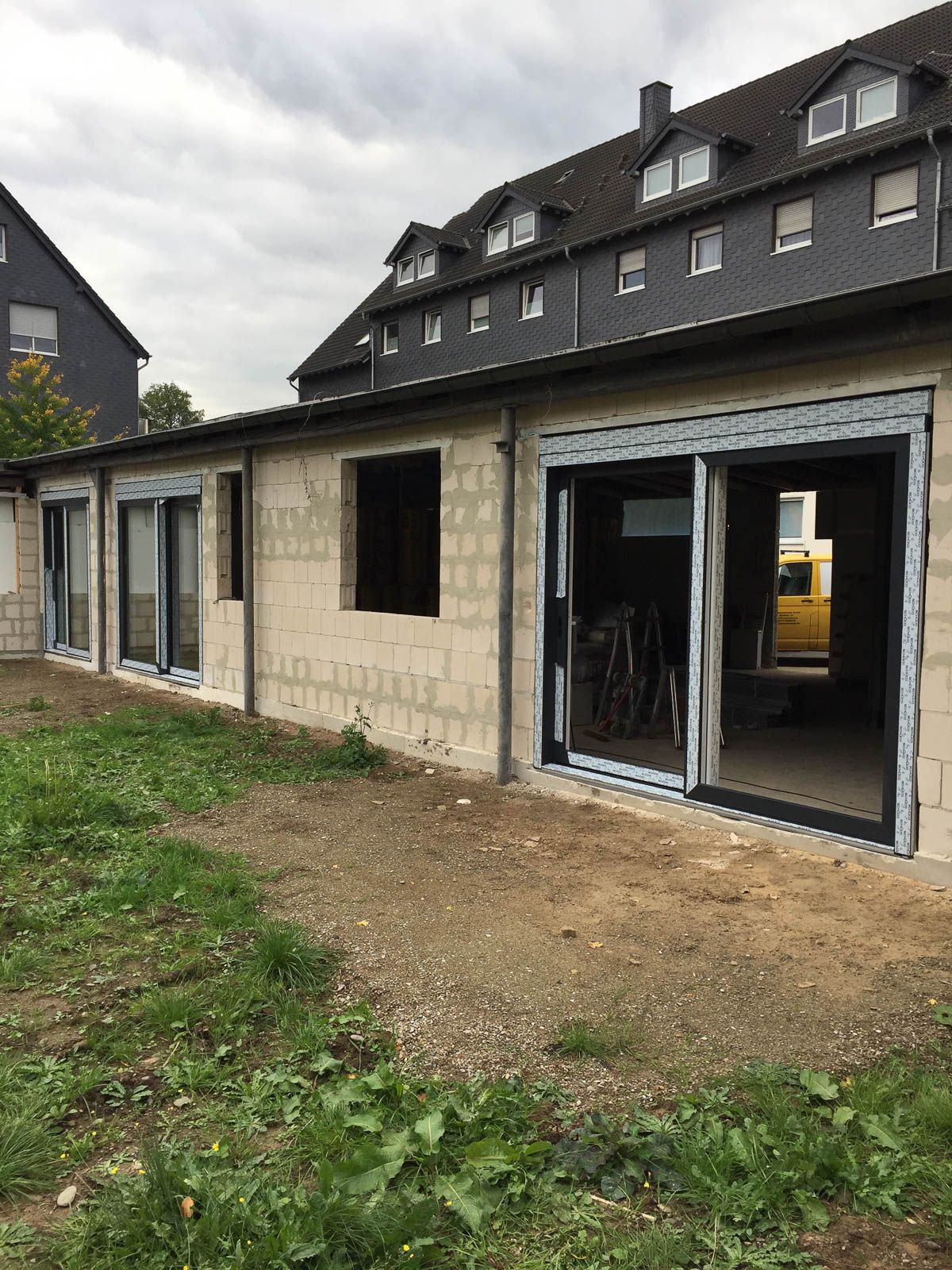 Ein im Bau befindliches Gebäude mit vielen Fenstern und Türen.