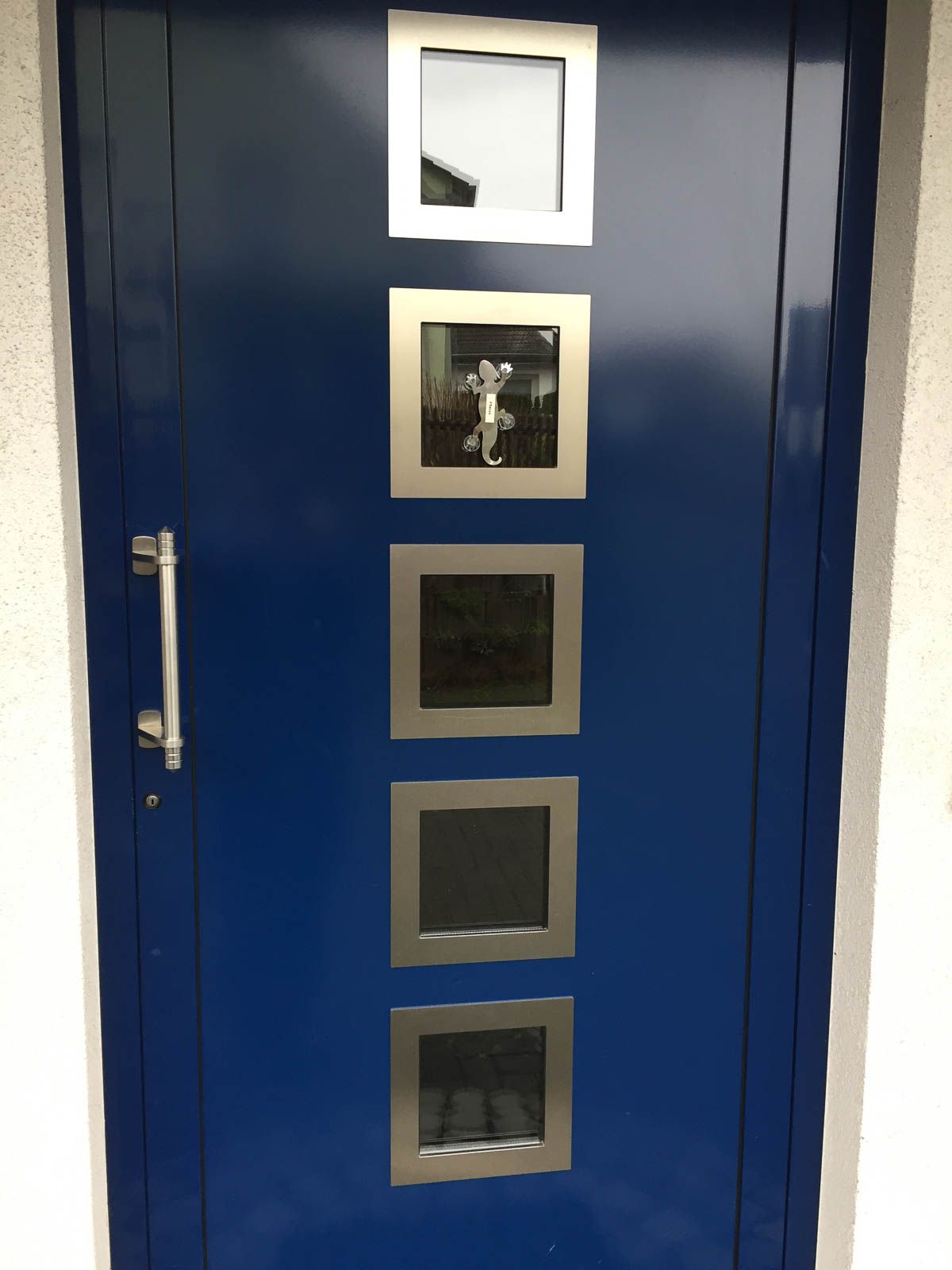 Eine blaue Tür mit quadratischen Fenstern