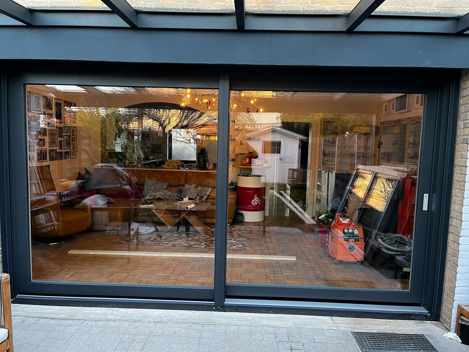 Ein Wohnzimmer mit vielen Fenstern und einer Glasschiebetür.