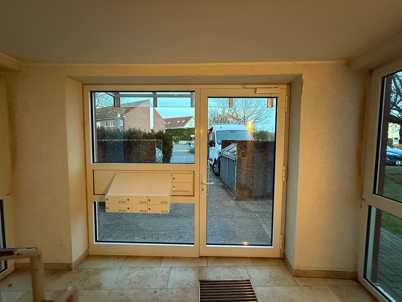 Ein Raum mit einem großen Fenster und einem Briefkasten an der Wand