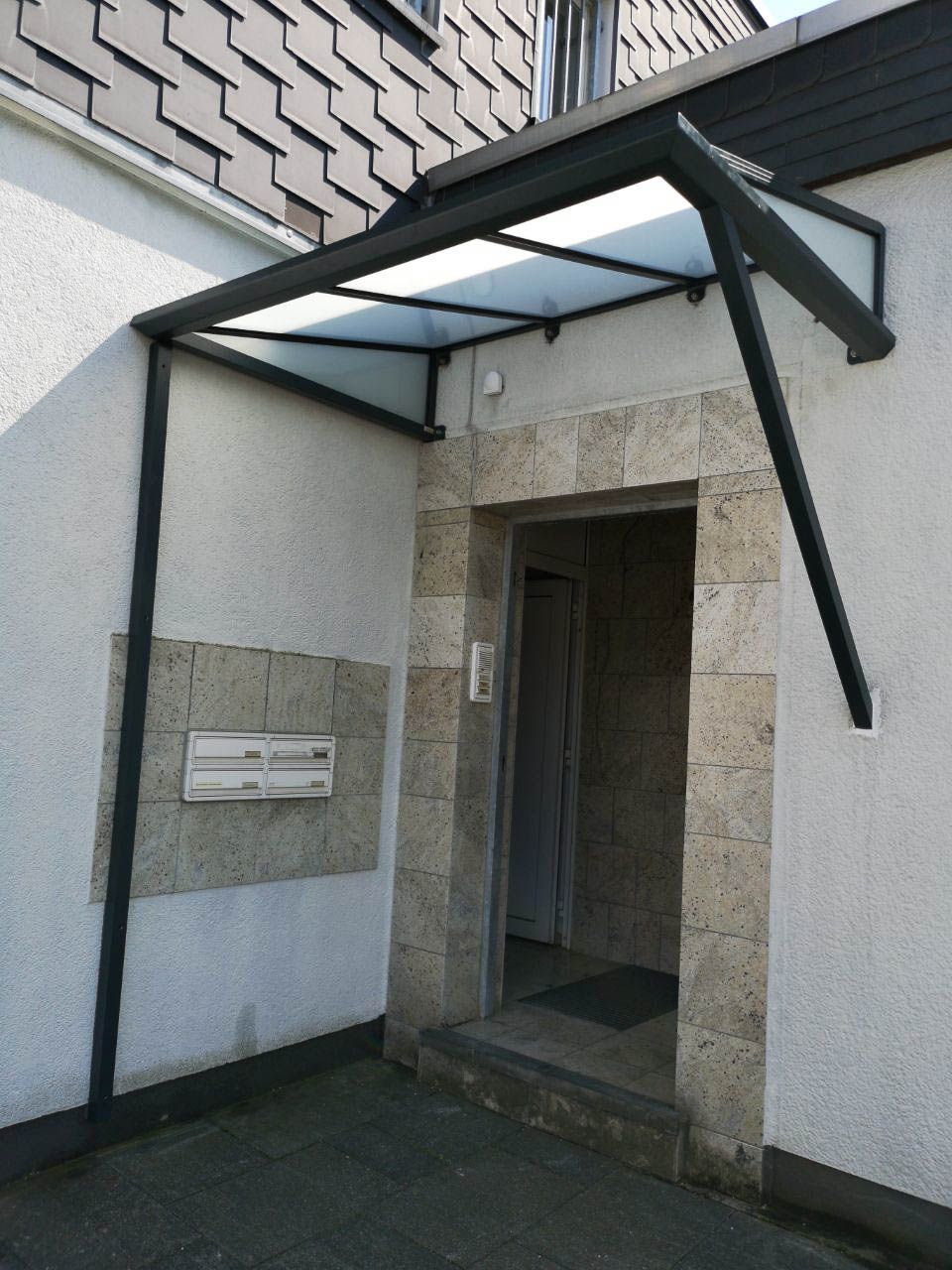 Ein weißes Gebäude mit einem Glasdach über dem Eingang