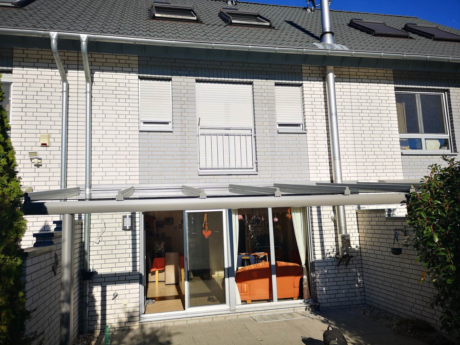 Ein weißes Backsteinhaus mit einer Glasschiebetür