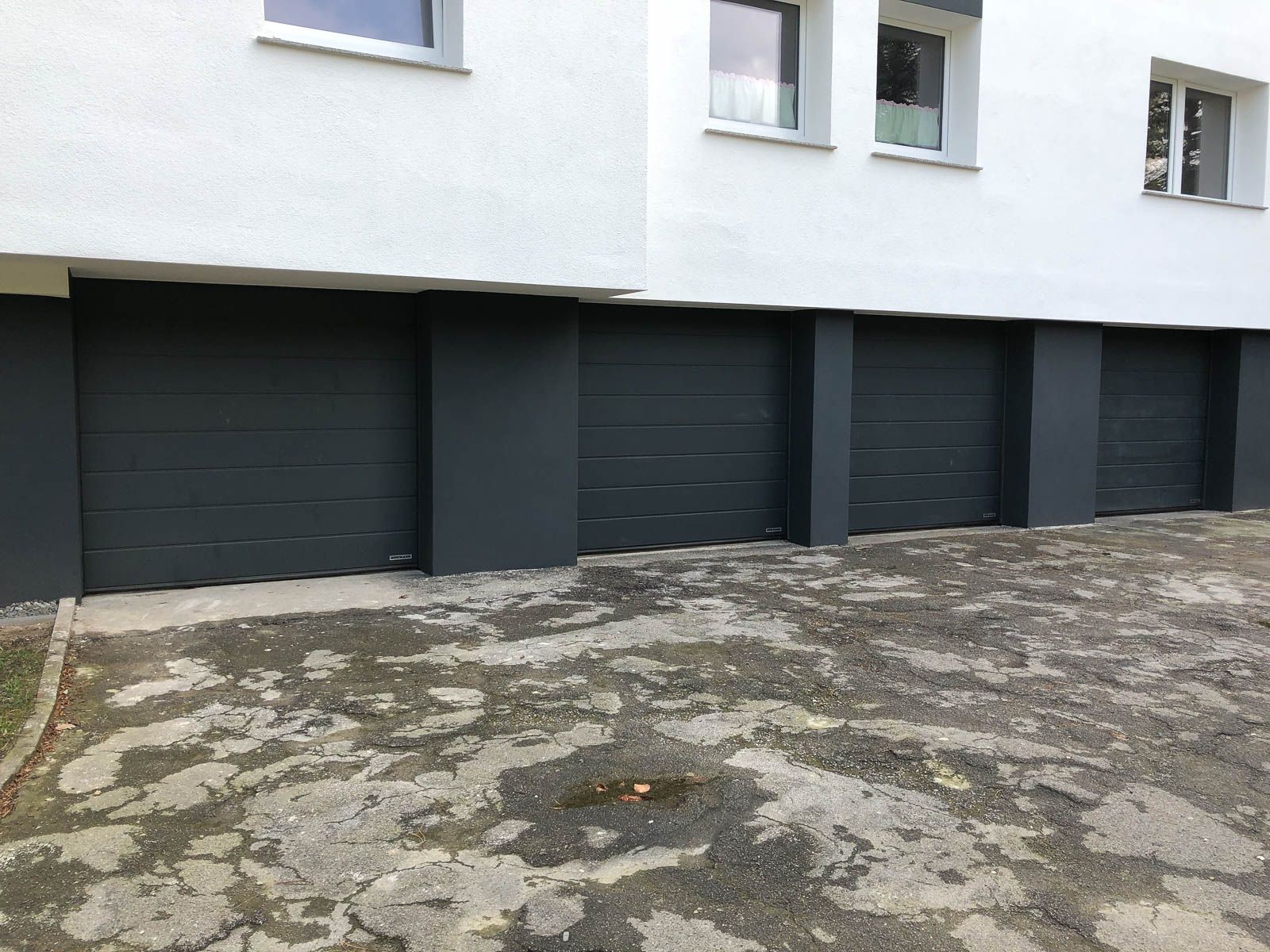 Eine Reihe von Garagentoren an der Seite eines Gebäudes.