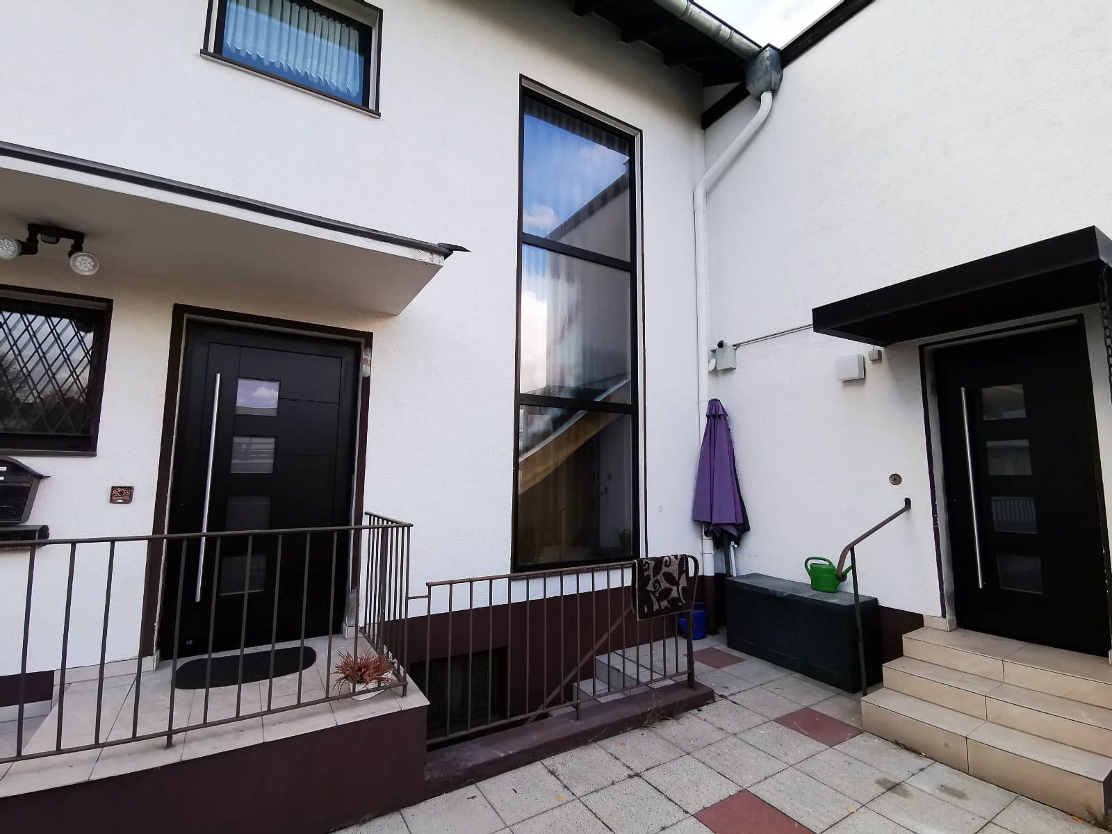 Ein weißes Haus mit schwarzen Türen und Fenstern