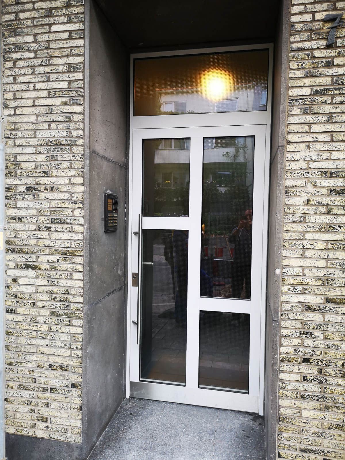 Eine weiße Tür mit einer Ziegelwand dahinter