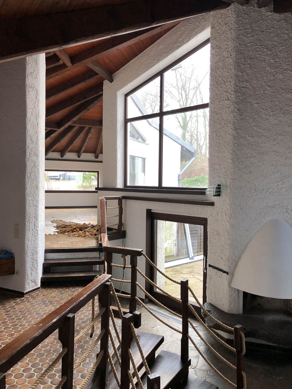 Ein Wohnzimmer mit Treppe zum zweiten Stock und einem Kamin.