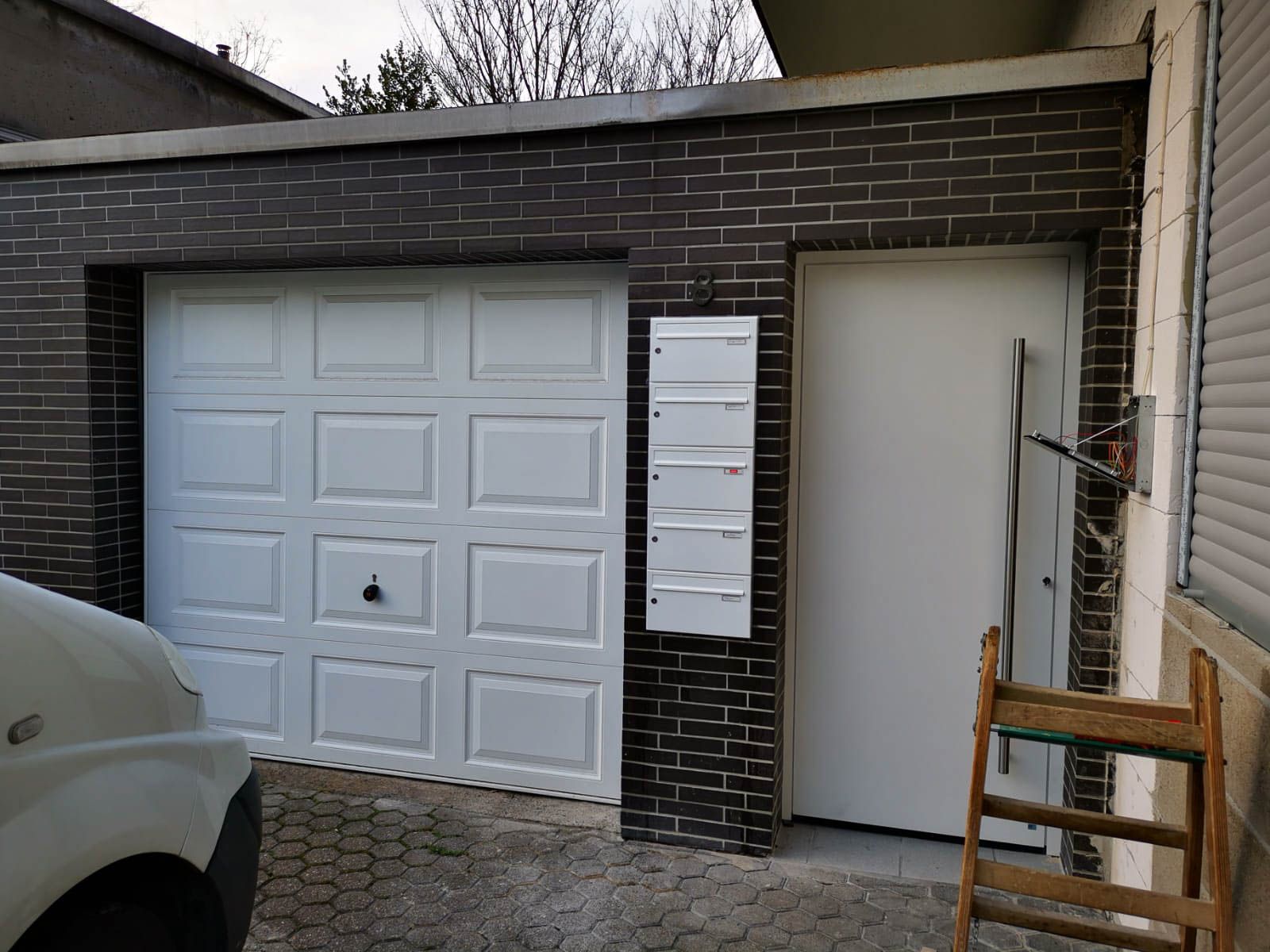 Ein weißer Lieferwagen steht vor einem Garagentor