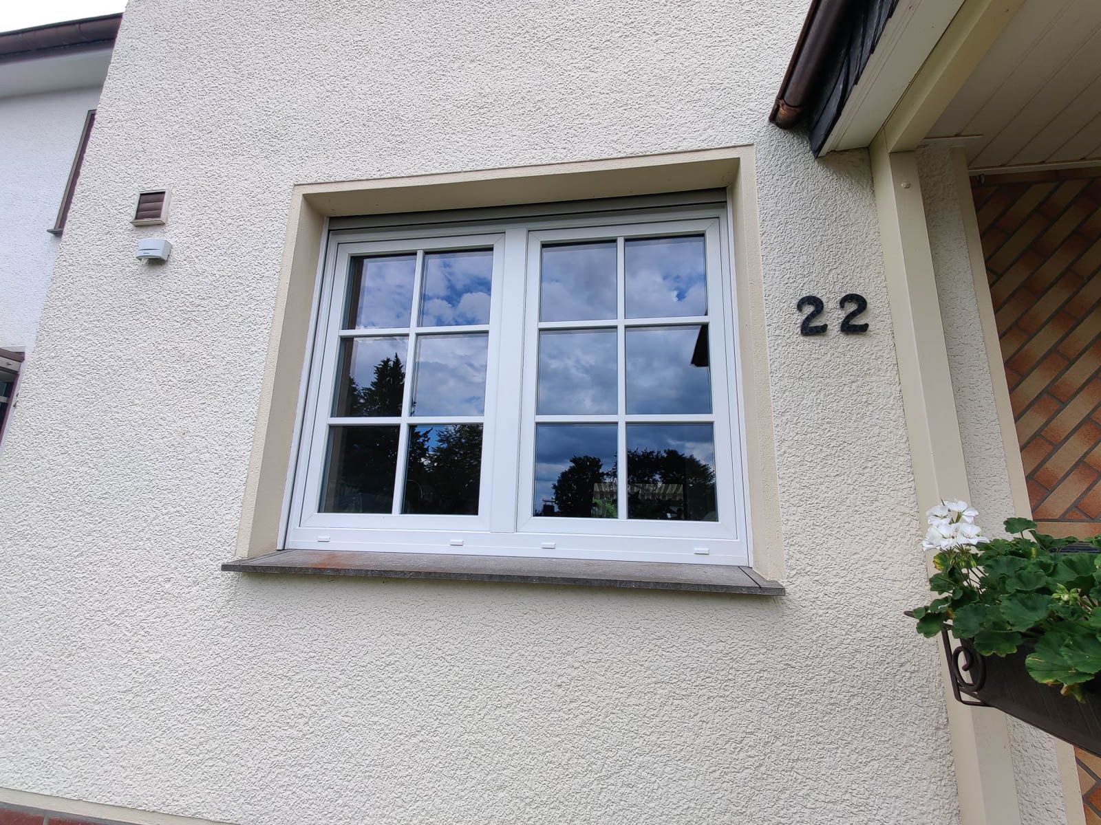 Ein weißes Fenster an der Seite eines Hauses mit der Nummer 22 darauf