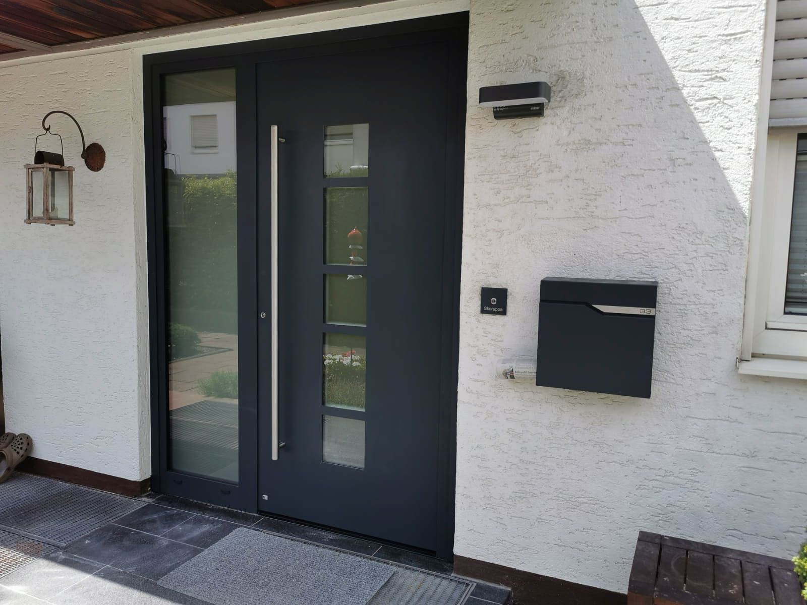 Die Haustür eines Hauses mit einer schwarzen Tür und einem Briefkasten.