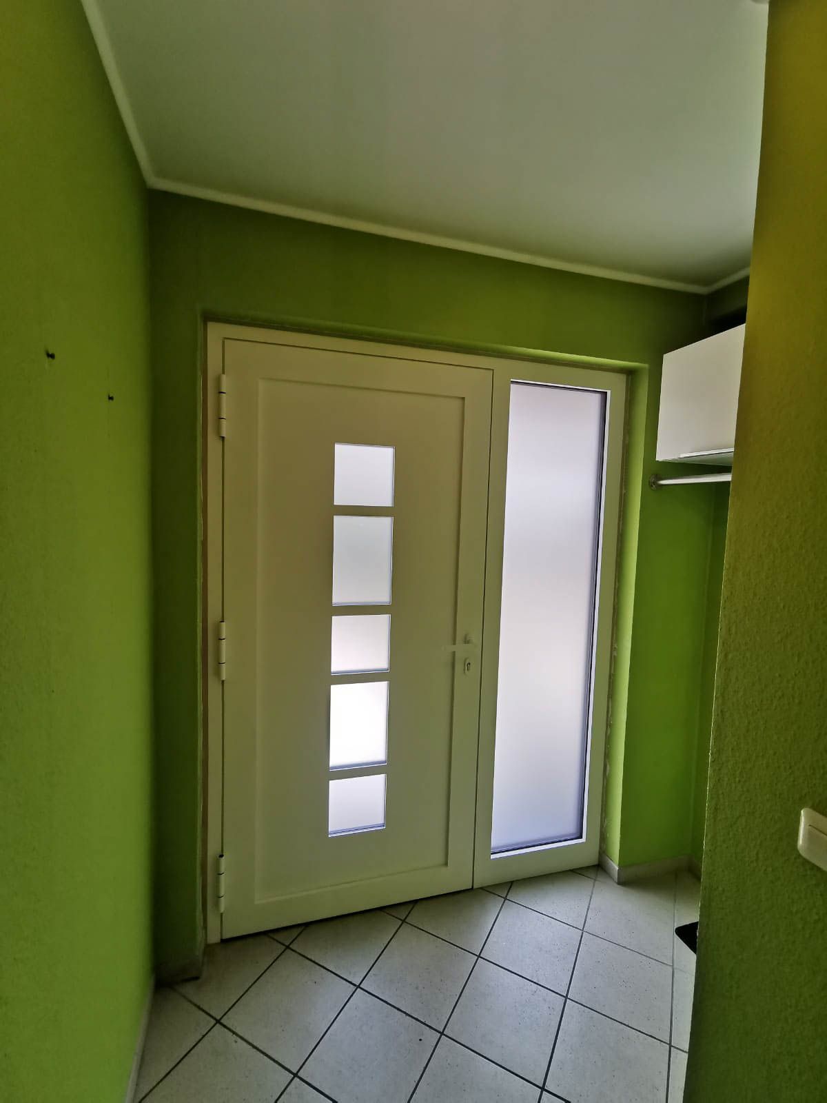 Ein Flur mit grünen Wänden und einer weißen Tür