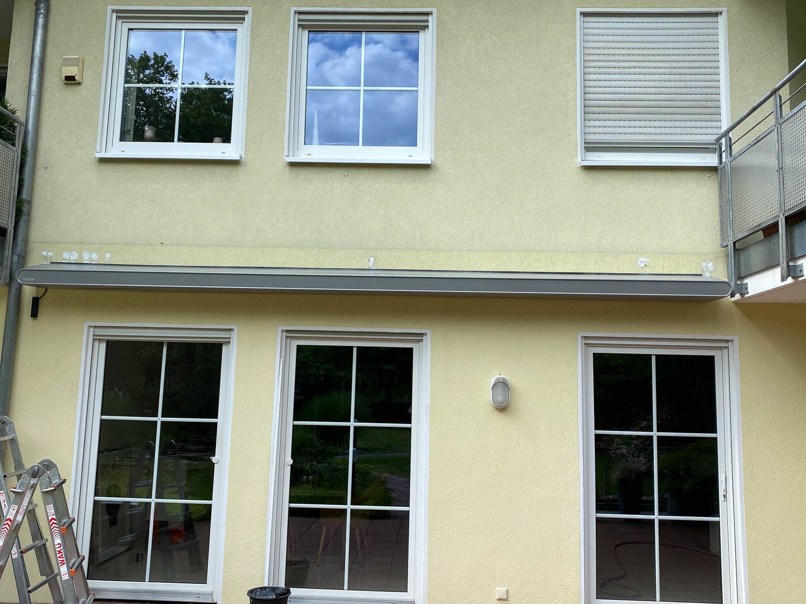 Ein gelbes Gebäude mit weißen Fenstern und einem Balkon