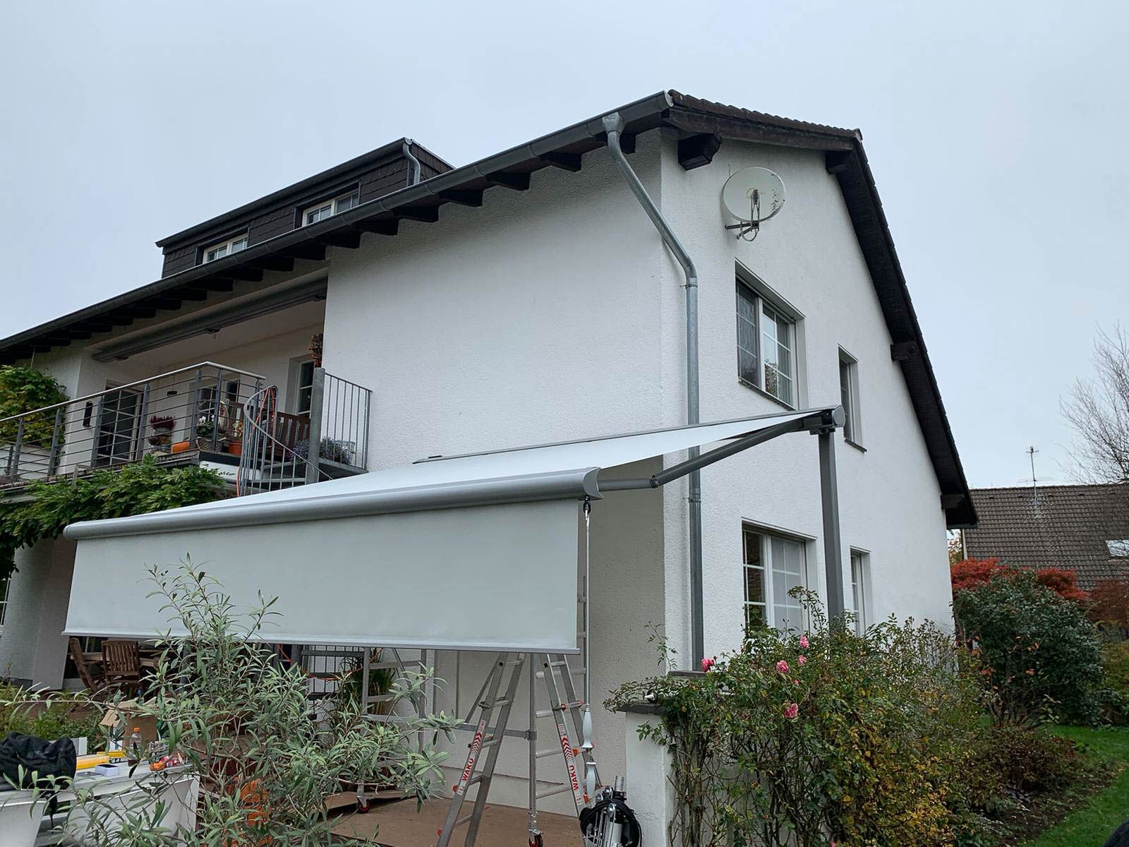 Ein weißes Haus mit einer weißen Markise an der Seite.