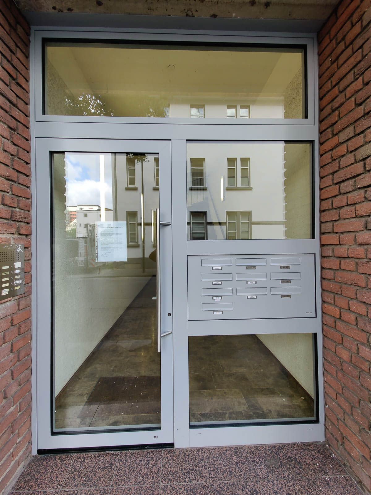 Ein Backsteingebäude mit einer Glastür und einem Briefkasten