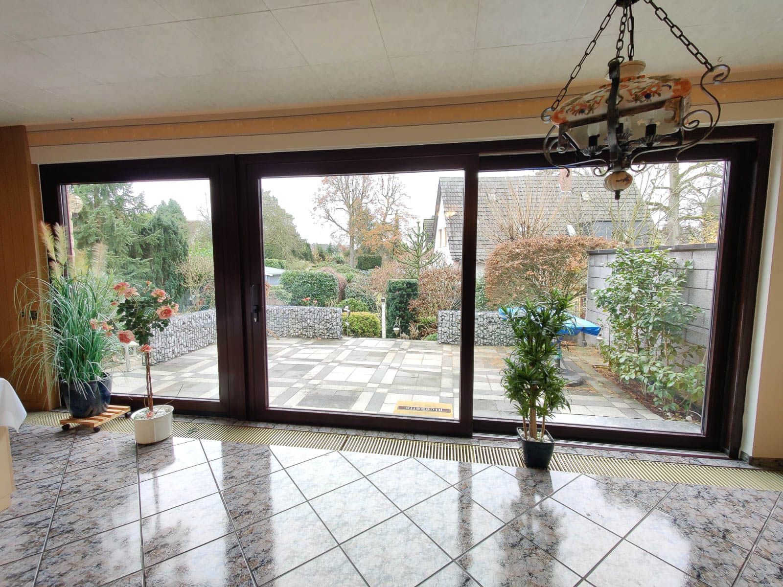 Ein Wohnzimmer mit einer Glasschiebetür und einem Kronleuchter.