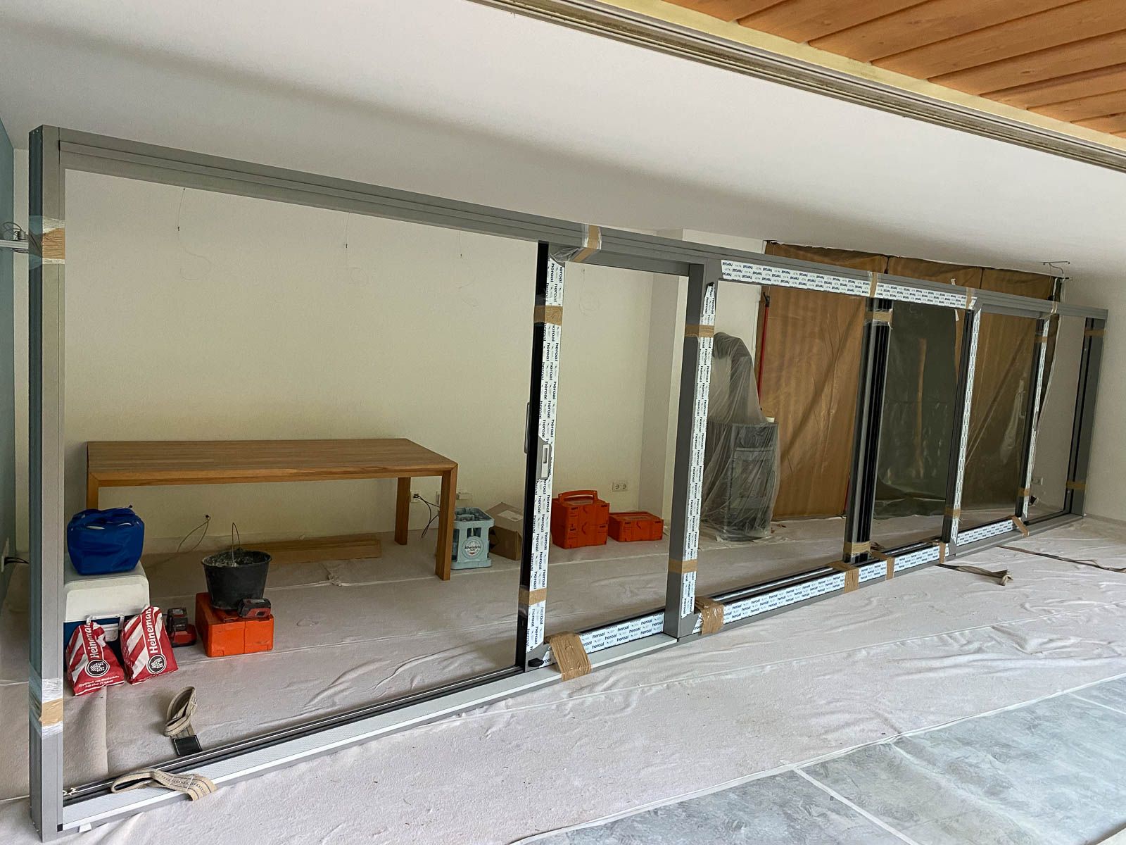 Ein Raum mit vielen Fenstern und einem Tisch darin.