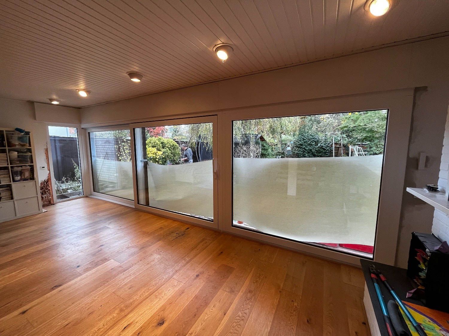 Ein Wohnzimmer mit Hartholzböden und vielen Fenstern.