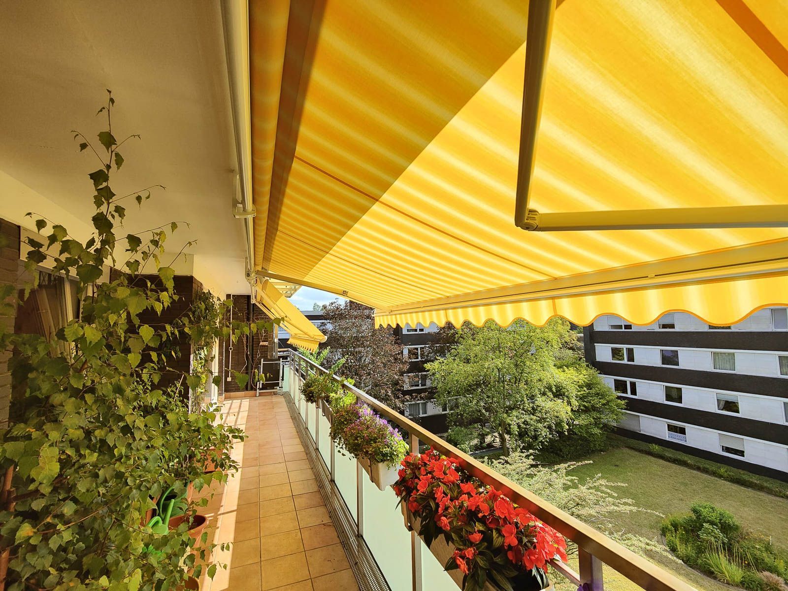 Ein Balkon mit einer gelben Markise darüber