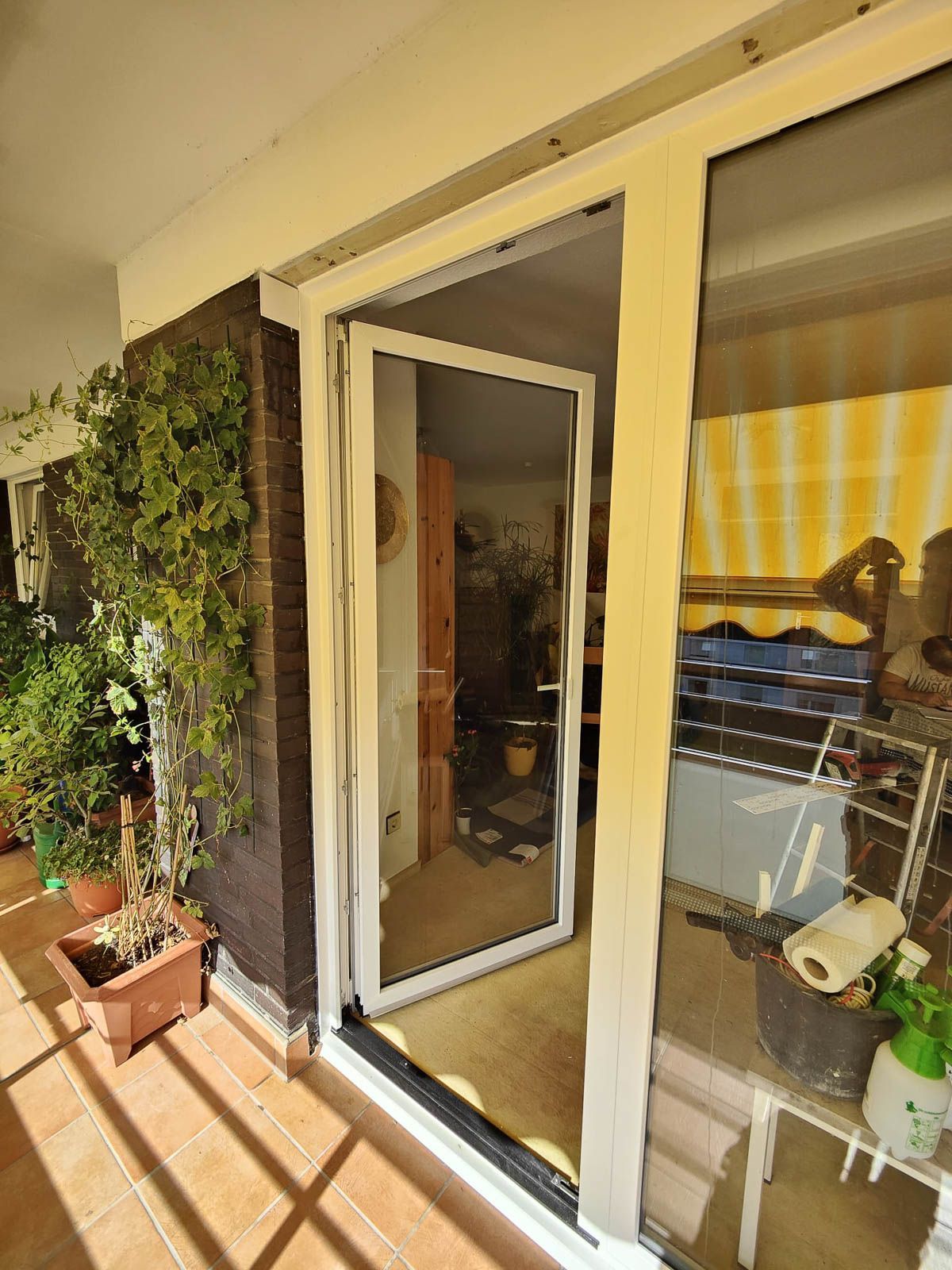 Ein Balkon mit einer Glasschiebetür, die zu einem Wohnzimmer führt.