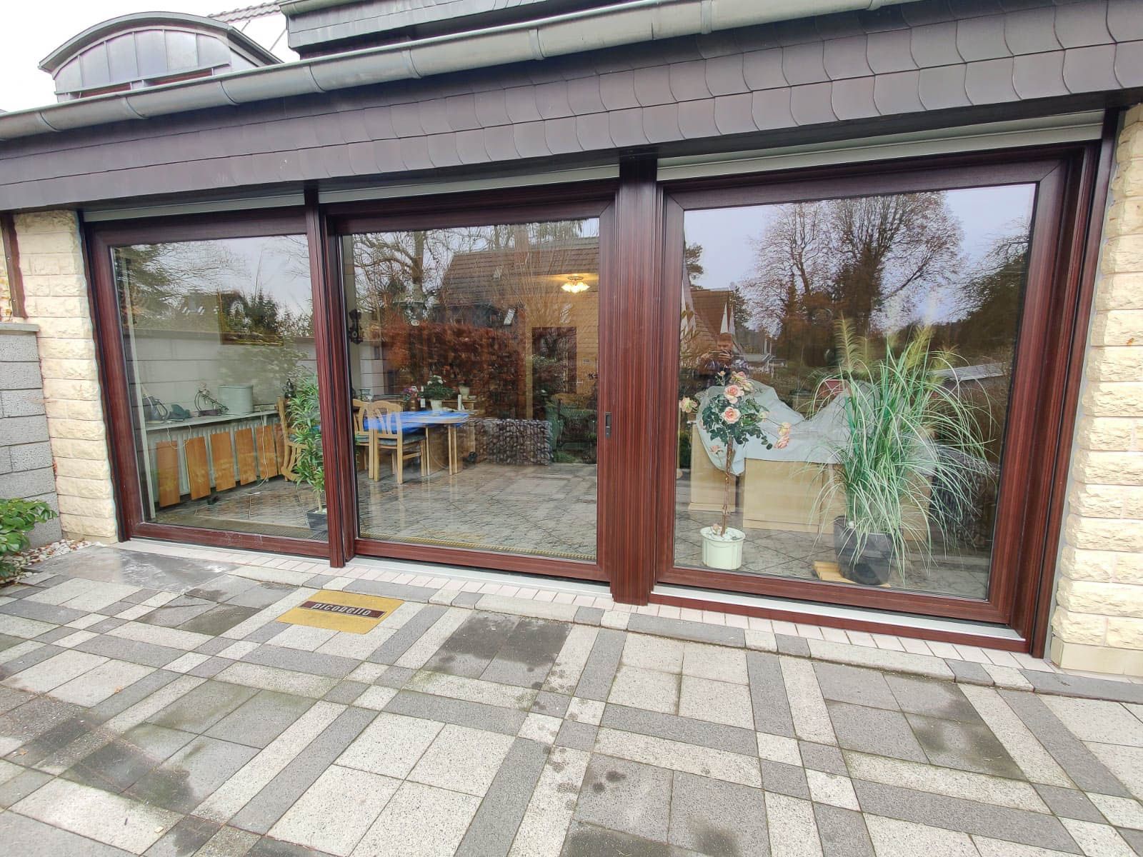 Ein Haus mit vielen Fenstern und einer Terrasse davor.