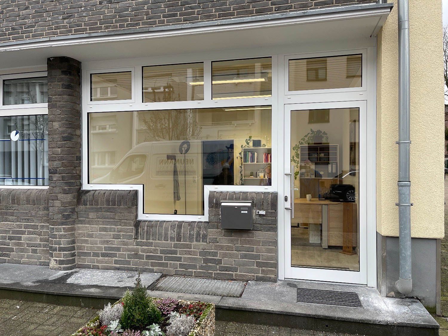 Ein Backsteingebäude mit einer weißen Tür und einem Briefkasten davor.