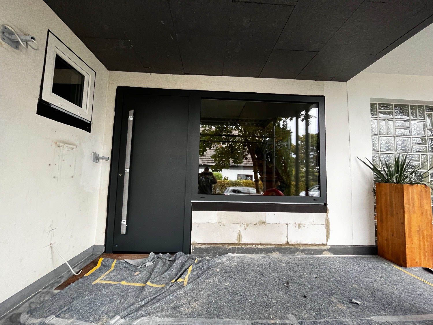 An der Seite eines Gebäudes wird eine schwarze Tür eingebaut.