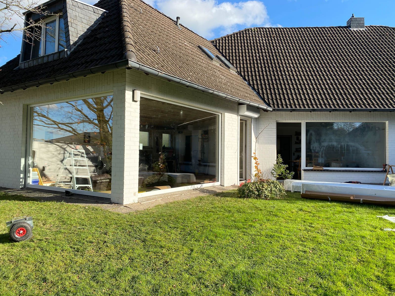 Ein Haus mit vielen Fenstern und einer großen Wiese davor.