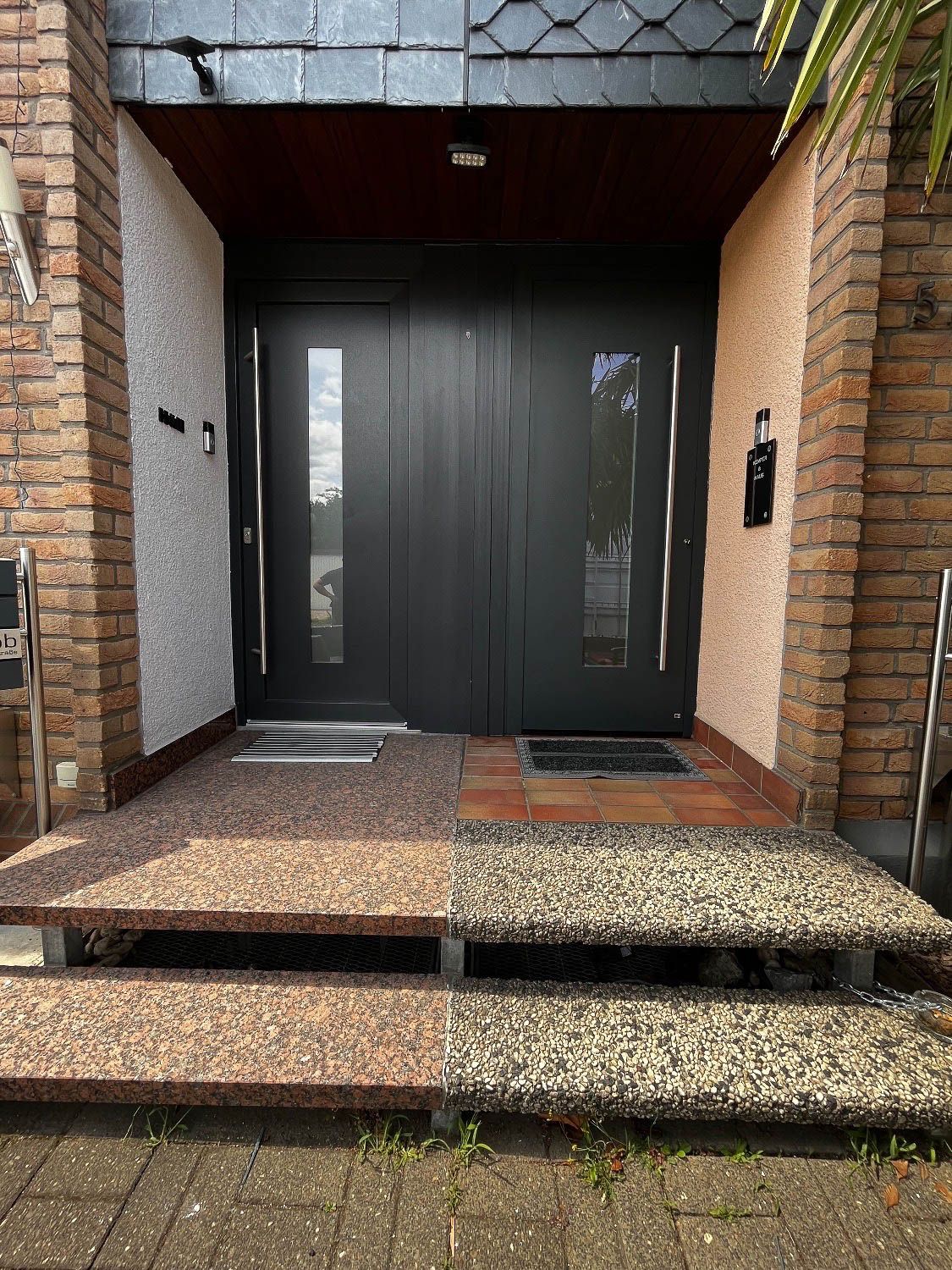 Die Vordertür eines Hauses, zu der eine Treppe hinaufführt.