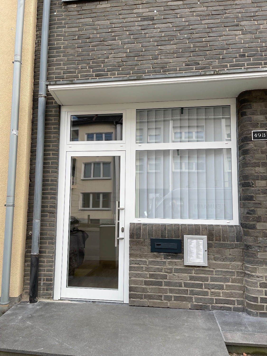Ein Backsteingebäude mit einer weißen Tür und einem Fenster