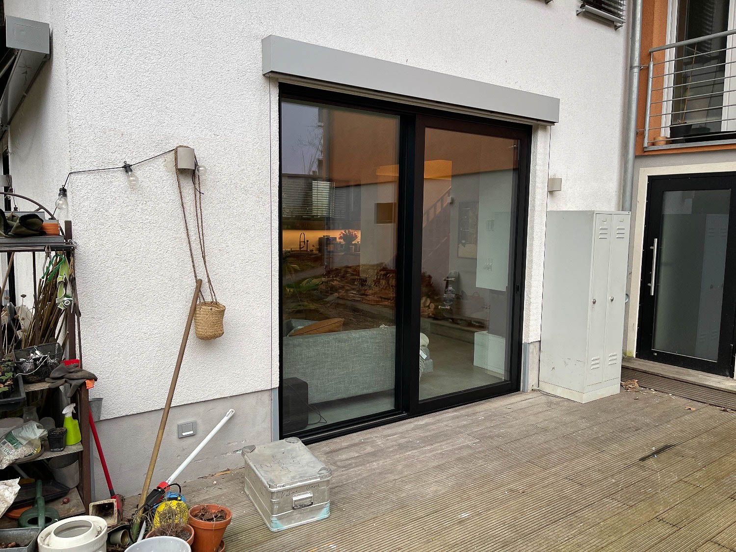 Im Hinterhof eines Hauses befindet sich eine Glasschiebetür.