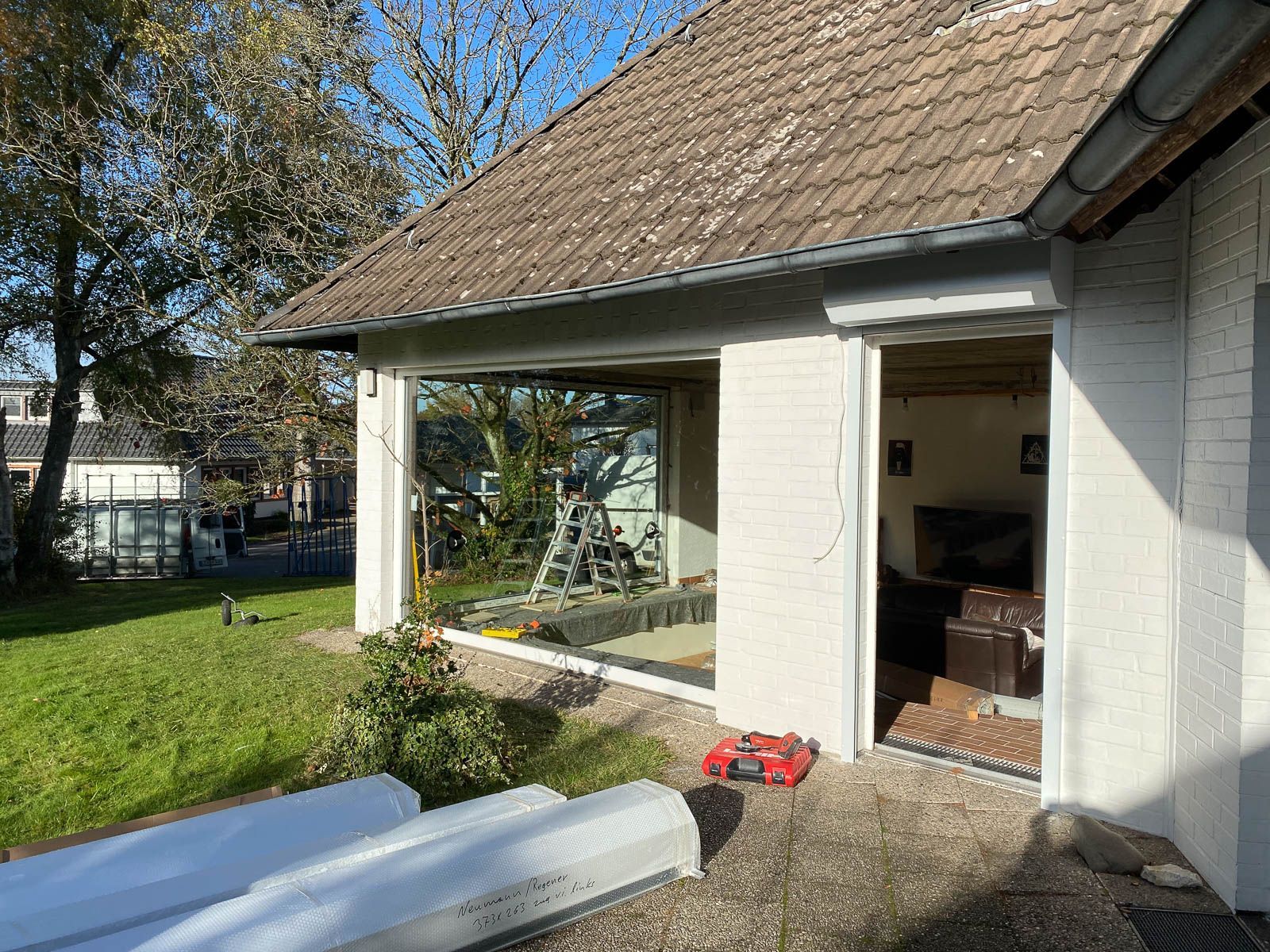 Ein weißes Haus mit braunem Dach wird umgebaut.