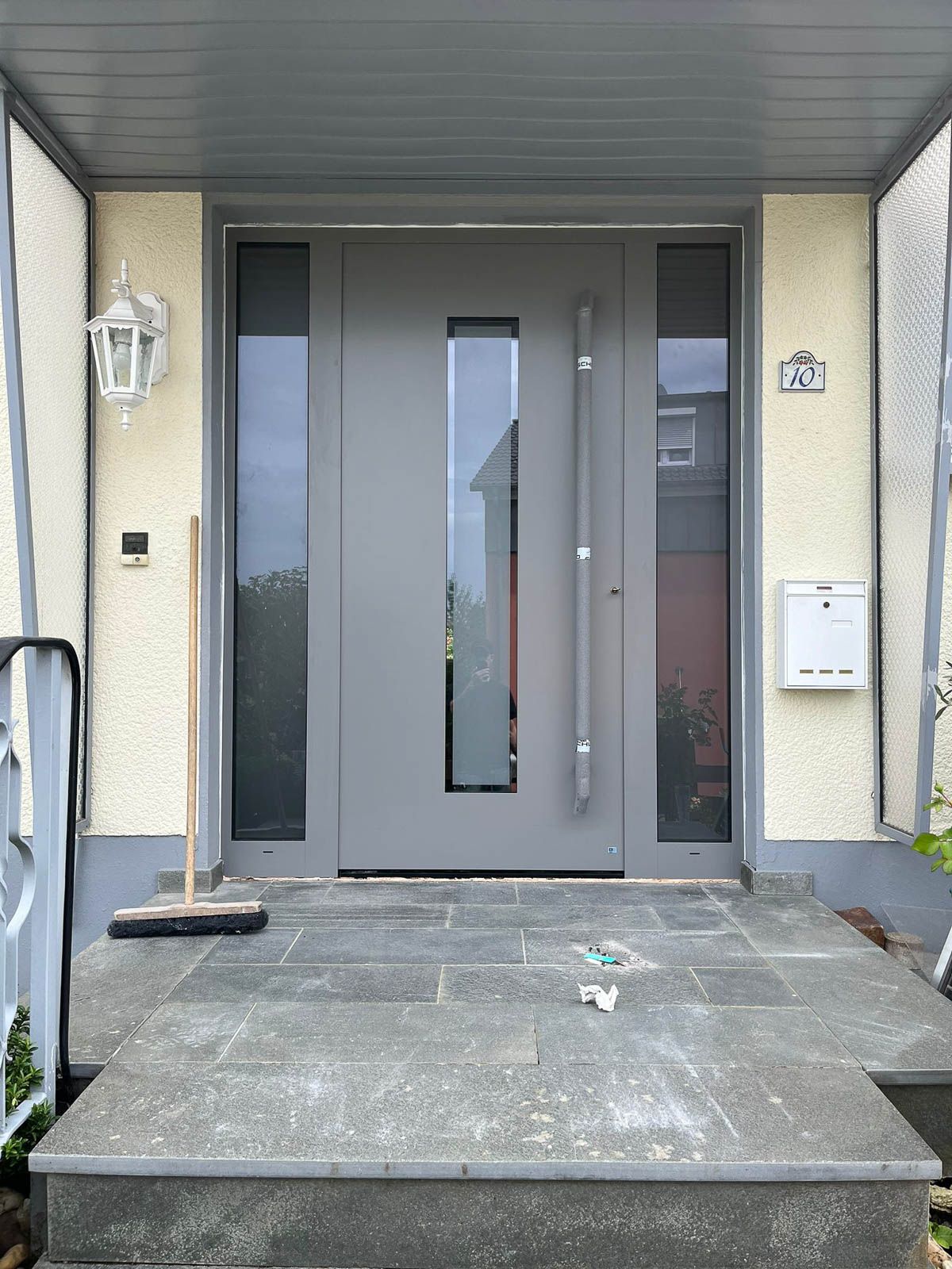 Die Haustür eines Hauses mit einem Besen davor.