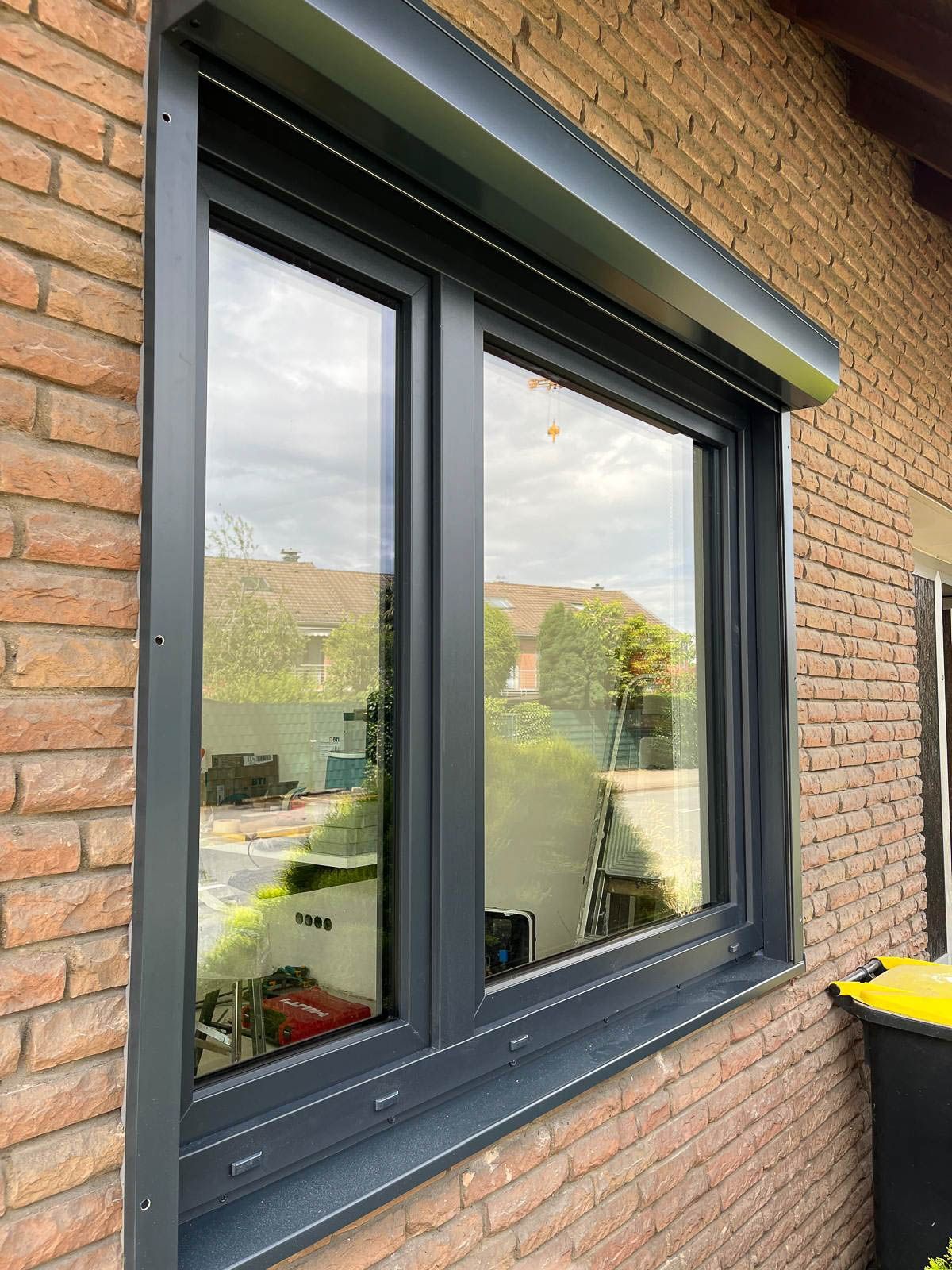 Ein Backsteingebäude mit einem schwarzen Fenster.