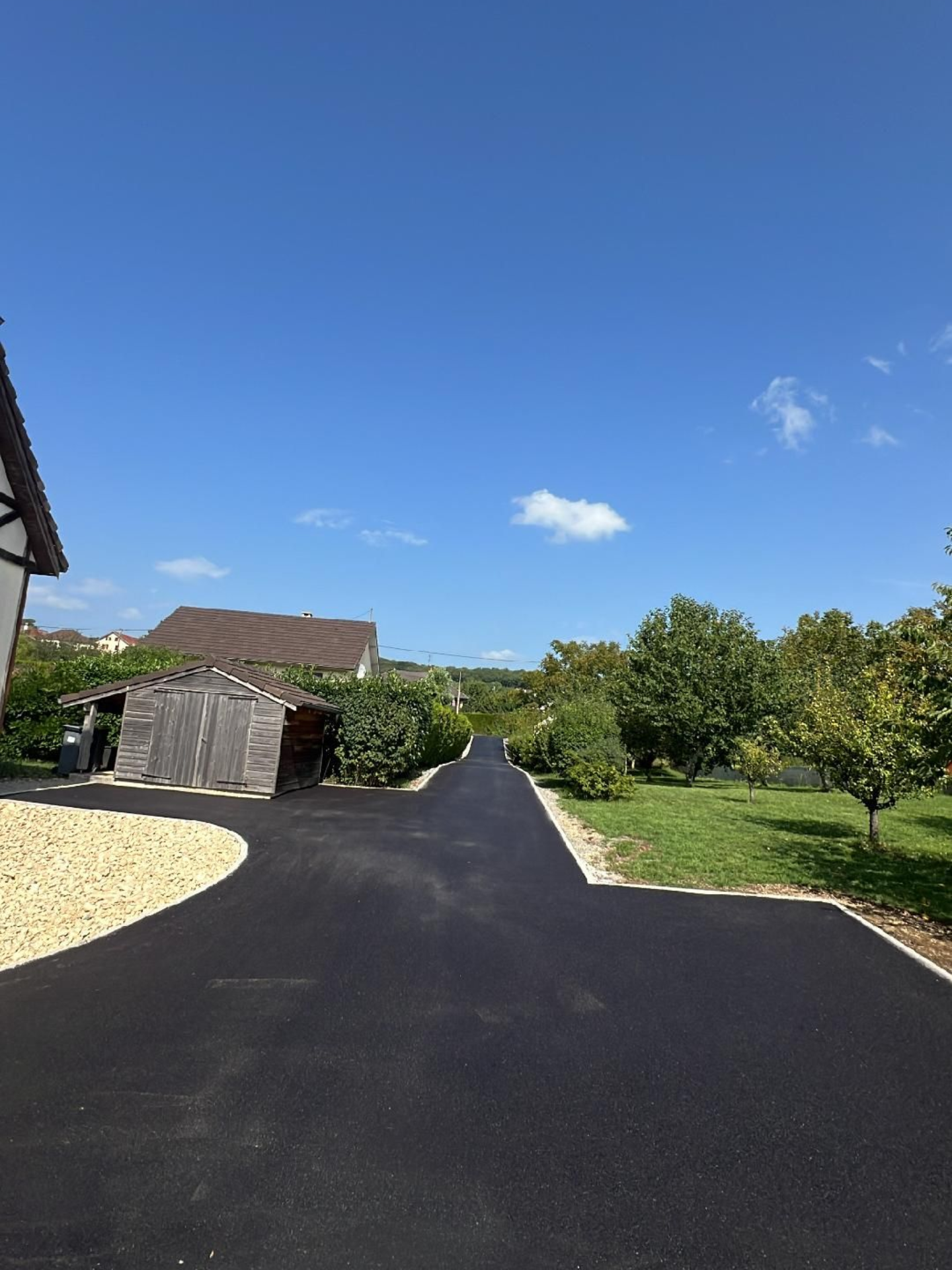 Une allée en pavés et fleurie.