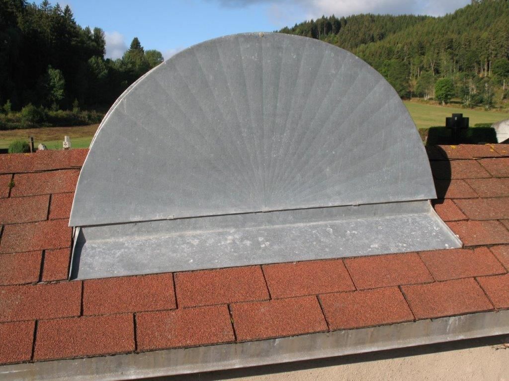 Halbrunde Dachgaube aus Metall auf einem Dach mit roten Dachziegeln
