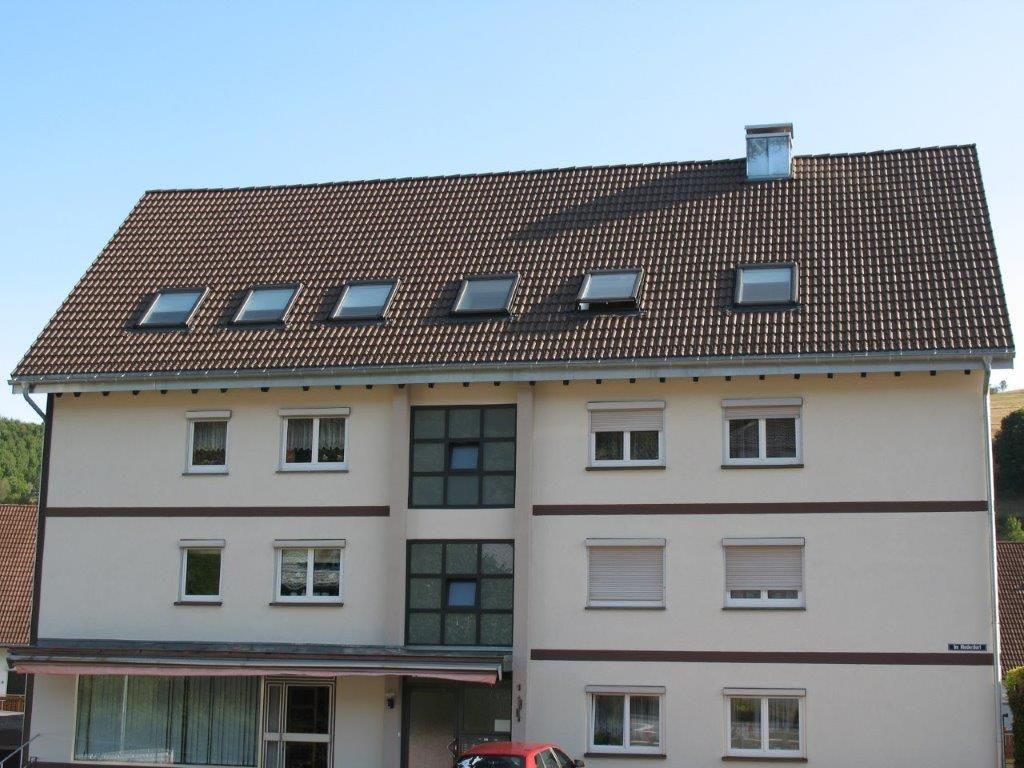 Mehrfamilienhaus mit Dachfenster-Reihe im braunen Satteldach