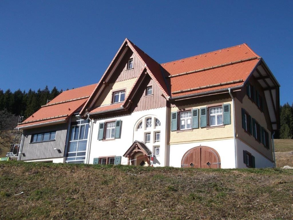 Traditionelles Schwarzwaldhaus mit steilem Walmdach und Klappläden