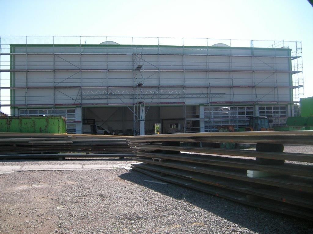 Baustelle eines Industriegebäudes mit Gerüst vor der Fassade