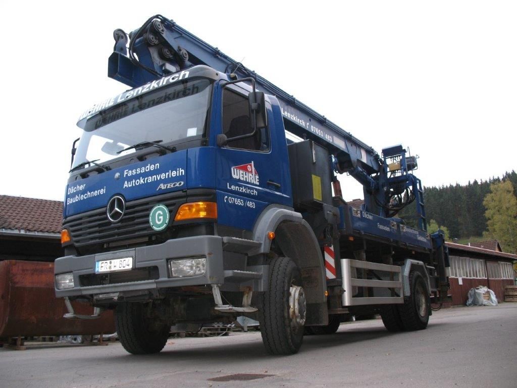 Seitenansicht eines blauen Mercedes-Benz LKWs mit Kran-Aufbau