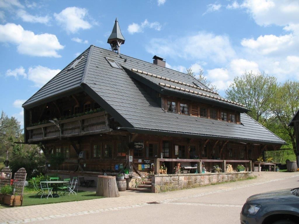 Ein großes, traditionelles Holzhaus mit aufwendigem Schindeldach und Holzbalkonen