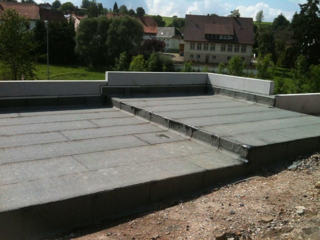 Blick auf ein Flachdach mit verschiedenen Oberflächen und Kiesschicht