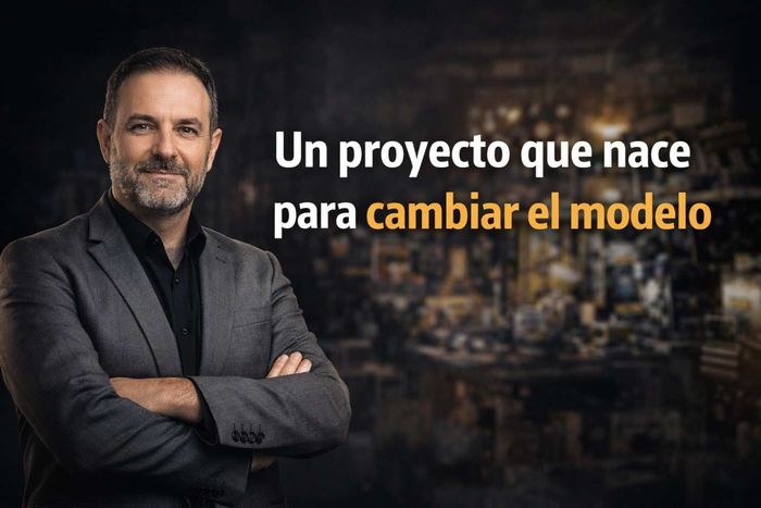 Un profesional sonriente con los brazos cruzados sobre un fondo borroso.