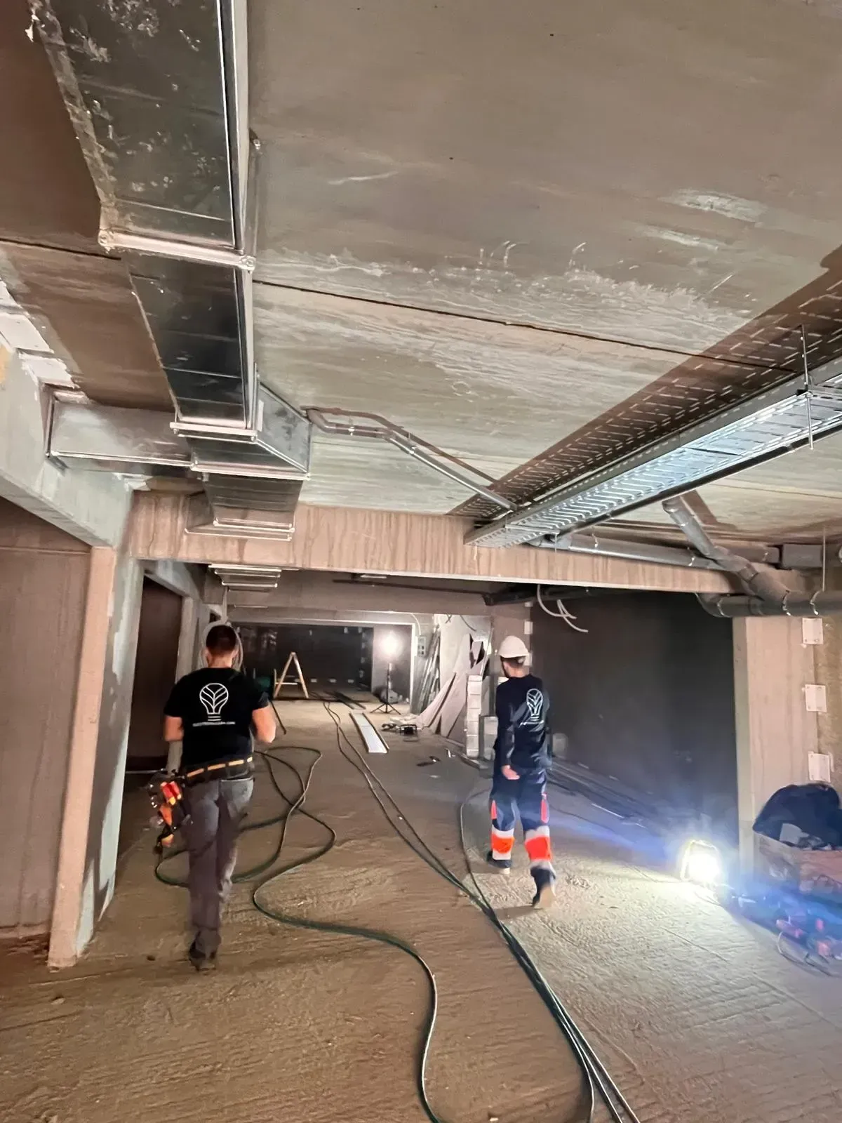 Dos personas con cascos de seguridad trabajan en una zona de construcción